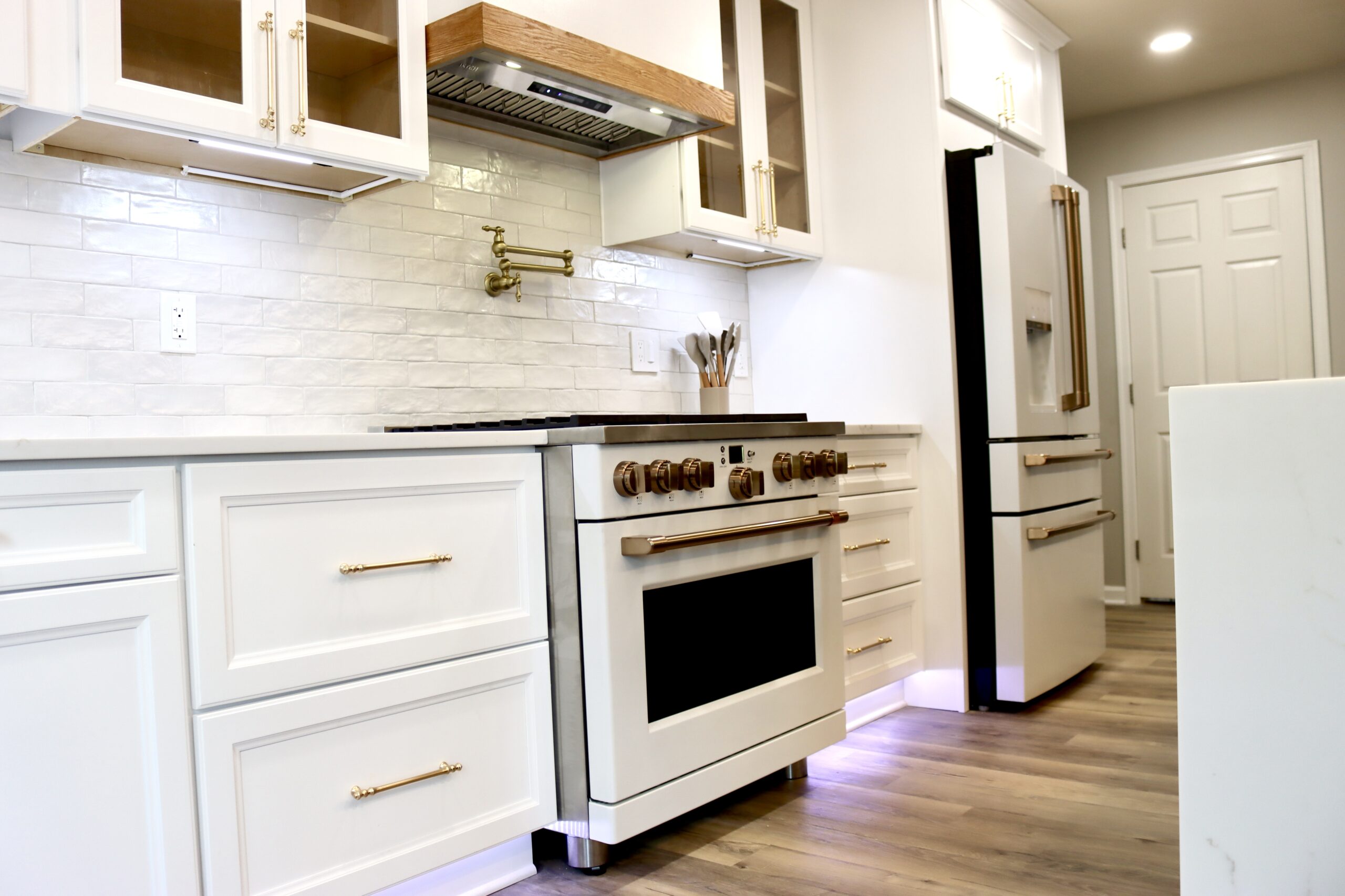 Modern luxe kitchen renovation with custom hood and dark stone feature wall by MSH Designed Renovations & Construction
