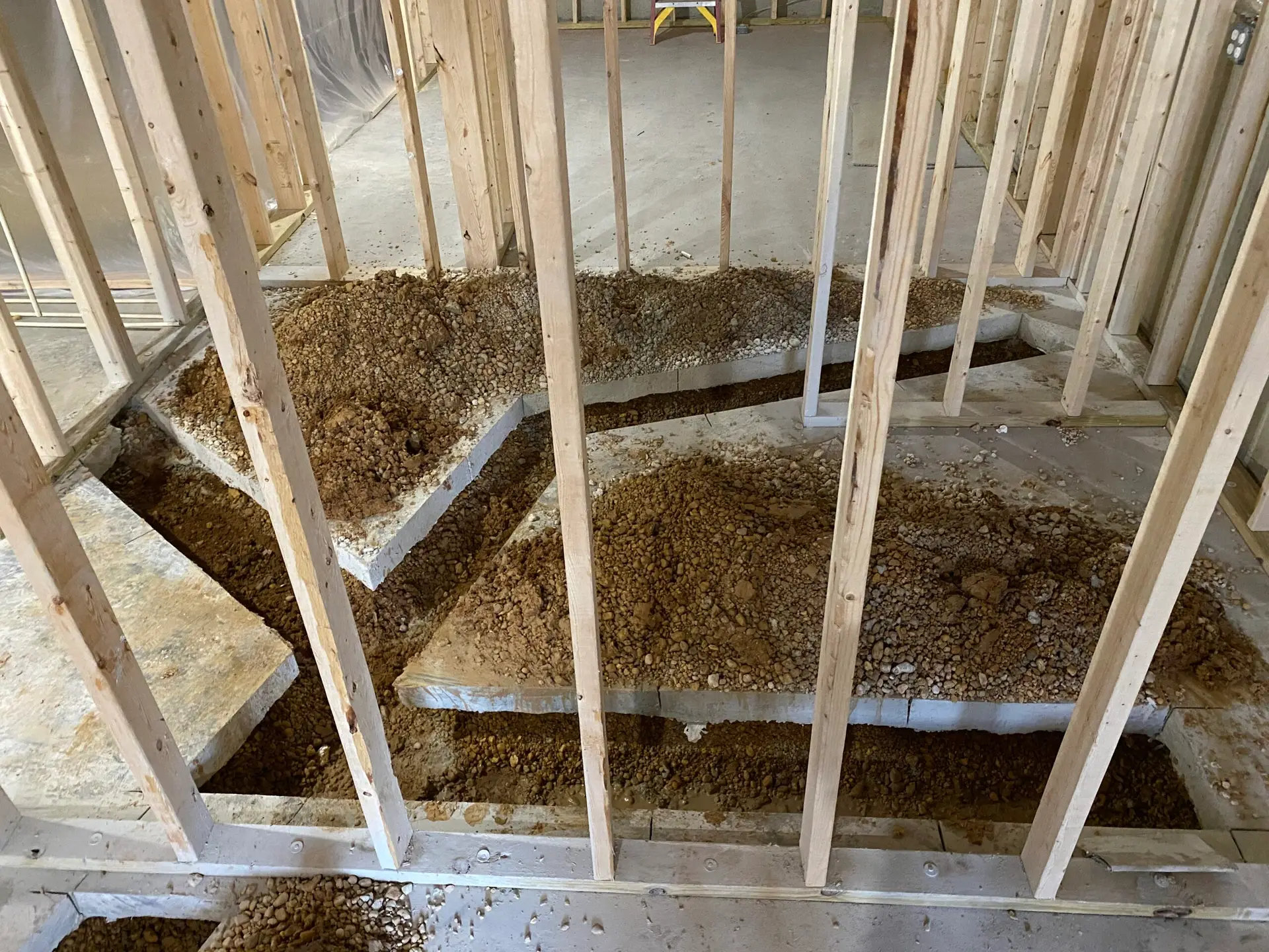 Unfinished basement with exposed framing and concrete